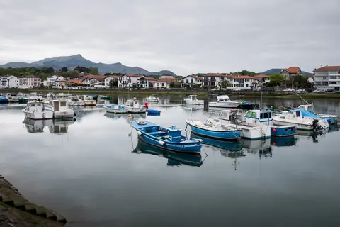 Bateaux amarrés sur la Nivelle à Saint-Jean-de-Luz, avec les montagnes basques en arrière-plan
